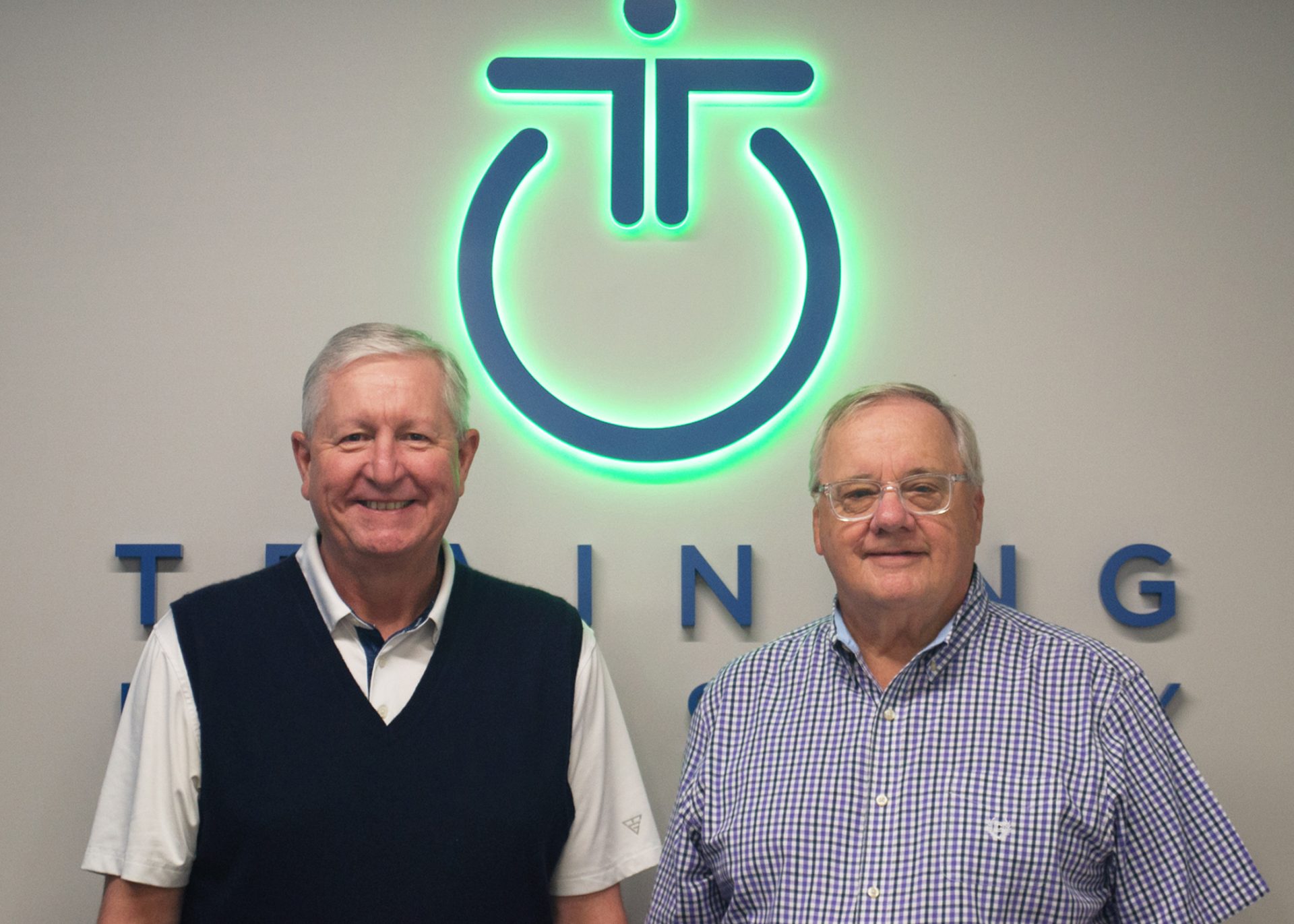 Picture of Ken Taylor and Doug Howard in front of Training Industry sign
